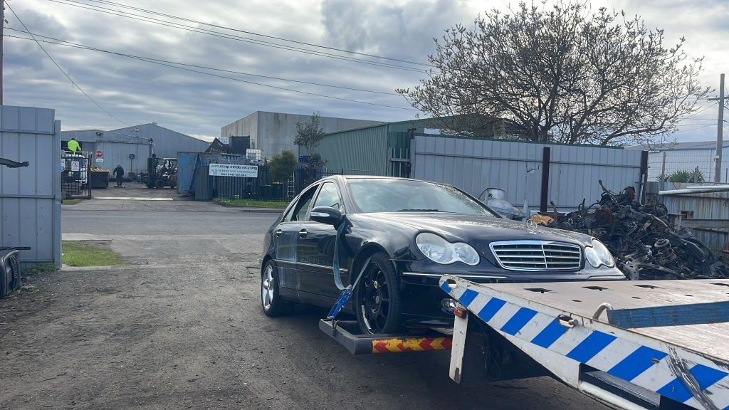 Tow truck removing an old and damaged car in Melbourne for cash